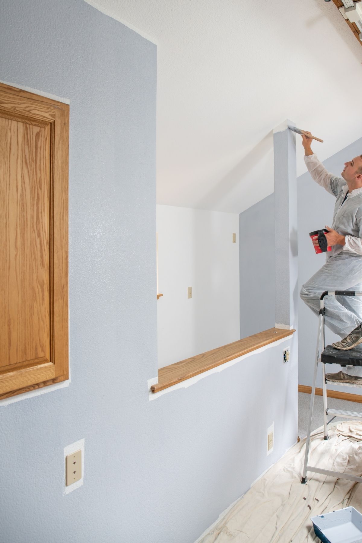 Peintre professionnel utilisant un rouleau pour peindre un mur intérieur à Lachute