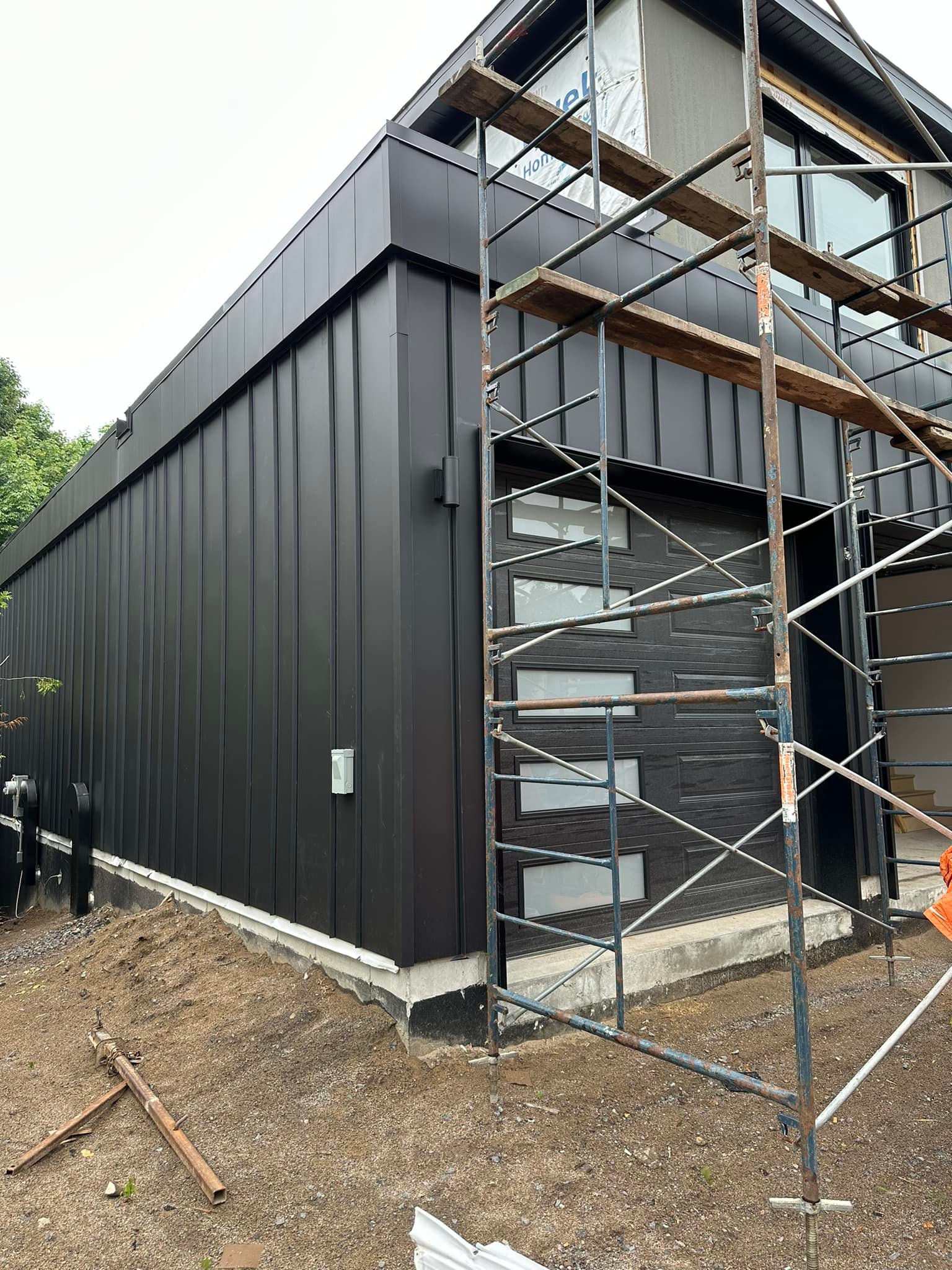 Peintre en bâtiment à Saint-Lambert-de-Lauzon appliquant une couche de peinture blanche